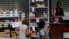 (FILE) People look at food prices in a private business in Havana.