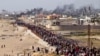(FILE) Palestinians wait for aid trucks to cross in central Gaza Strip on May 19, 2024. 