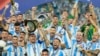 Argentina's Lionel Messi holds the trophy as celebrating with teammates after defeating Colombia in the Copa America final soccer match in Miami Gardens, Florida, July 15, 2024. 