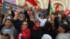 Demonstrators chant slogans while lifting Tunisian and Palestinian flags at a rally organized by the National Salvation Front opposition alliance in Tunis, May 12, 2024, to call for the release of arrested opposition figures. 