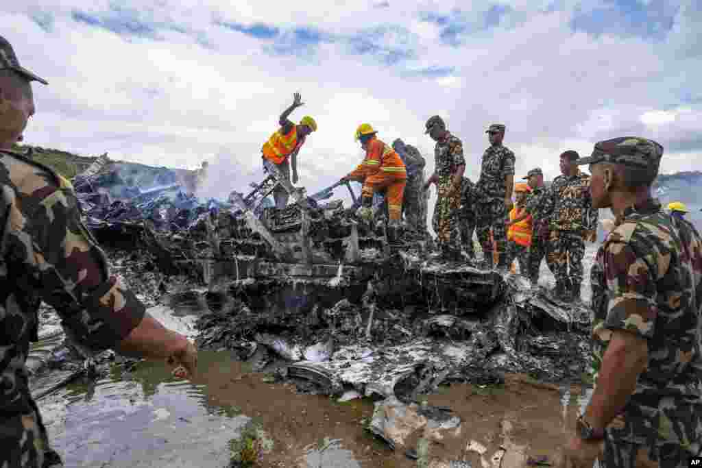 Nepal army personnel sort through the debris after a domestic plane belonging to Saurya Airlines crashed just after taking off at Tribhuvan International Airport in Kathmandu. (AP Photo/Prabin Ranabhat)