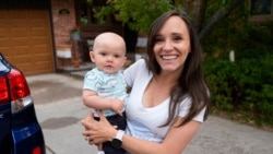 Carrie Martin-Haley menggendong anaknya di luar rumahnya di Greenwood Village, Colorado, pada 10 Mei 2024. Colorado mulai memberlakukan cuti kesehatan dan cuti keluarga berbayar awal tahun ini. (Foto: AP/David Zalubowski)