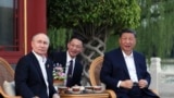 Russian President Vladimir Putin, left, and Chinese President Xi Jinping, right, attend an informal meeting in Beijing, May 16, 2024. 