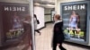 资料照：英国伦敦一名女子走过地铁走道旁中国便宜服装快时尚品牌Shein的广告牌。（2024年3月8日）
