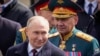 资料照片：2024 年 5 月 9 日，俄罗斯总统弗拉基米尔·普京（左）和俄罗斯国防部长谢尔盖·绍伊古在俄罗斯莫斯科举行胜利日阅兵式后离开红场。在内阁改组中，普京于 5 月 12 日更换绍伊古的国防部长职务 。
