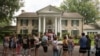 FILE - Fans wait outside Graceland, Aug. 15, 2017, in Memphis, Tenn. The granddaughter of Elvis is fighting plans to publicly auction his Graceland estate after a company tried to sell the property based on claims that a loan was not repaid.