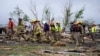 Firefighters walks among tornado-damaged homes, in Greenfield, Iowa, May 21, 2024.