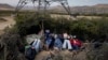 FILE - Migrants sleep in a makeshift campsite as they wait to apply for asylum after crossing the border, May 10, 2023, near Jacumba, Calif. This image was part of an AP series on migration that won a Pulitzer Prize for feature photography.