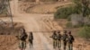 资料照片：以色列军人在以色列南部的加沙边境地区行进。(6月13日)