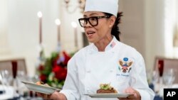 FILE - White House executive chef Cris Comerford, holds dishes as she speaks during a media preview for the State Dinner with President Joe Biden and French President Emmanuel Macron, Nov. 30, 2022.