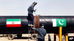 FILE - Iranian welders work on a pipeline to transfer natural gas from Iran to Pakistan, in Chabahar, near the Pakistani border, southeastern Iran, March 11, 2013.