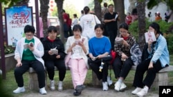 FILE - Students review their exam preparation materials in the last minutes before the National College Entrance Exam, or Gaokao, outside an exam venue in Hai'an city in east China's Jiangsu province on June 7, 2024. (Chinatopix via AP)