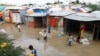 Somali children wade through floodwaters outside their makeshift shelters following heavy rains at the Al Hidaya camp for the internally displaced people on the outskirts of Mogadishu, Somalia, Nov. 6, 2023