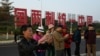中國福建廈門豎立起一個台灣金門島可以看到的「一國兩制統一中國」的大型標語牌，旅遊者在前拍照。 （2024年1月12日）