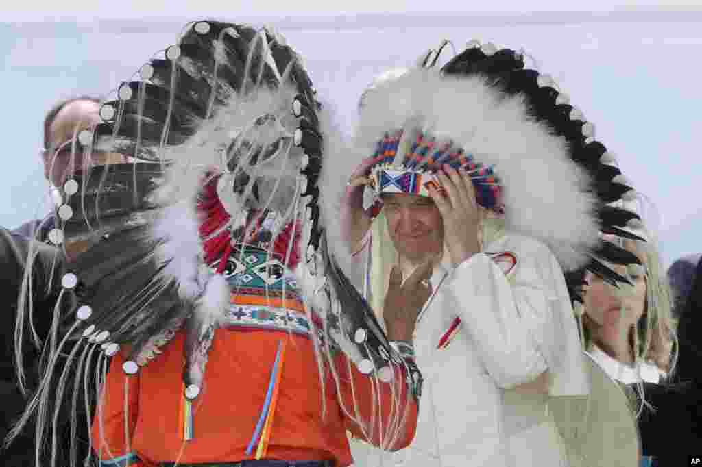 Pope Francis puts on an indigenous headdress during a meeting with indigenous communities, including First Nations, Metis and Inuit, at Our Lady of Seven Sorrows Catholic Church in Maskwacis, near Edmonton, Canada, July 25, 2022