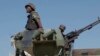 (FILE) In this image made from video, a Mozambican soldier rides on an armored vehicle at the airport in Mocimboa da Praia, Cabo Delgado province, Mozambique, Aug. 9, 2021.