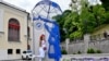 Дівчинка біля скульптурної композиції "Українка під парасолькою НАТО" творчої майстерні ARTBUZ під час святкування Дня вишиванки у Києві 16 травня 2024 року. Sergei SUPINSKY/AFP
