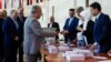 (FILE) Syrian Prime Minister Hussein Arnous and Syrian Foreign Minister Faisal Mekdad arrive to a polling station to cast their votes during the Syrian parliamentary election in Damascus, Syria, Monday, July 15, 2024.