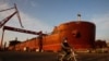 중국 남부 광저우시 룽쉐 조선소에서 한 노동자가 '중국선박중공집단공사(중선중공)'이 제조한 선박 옆으로 자전거를 타고 지나가고 있다. (자료사진)