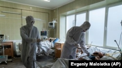 Медпрацівник біля пацієнта, хворого на коронавірус, у відділі інтенсивної терапії лікарні швидкої медичної допомоги у Львові, 9 січня 2021 року