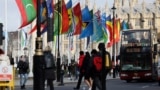 FILE - People ride a bus past flags representing Commonwealth countries next to Westminster Abbey in London on March 13, 2023. The Commonwealth is scheduled to meet Oct. 21-25, 2024, in Samoa.