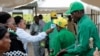 FILE - Party members have their temperature checked and sanitize their hands as a precaution against the coronavirus at the national congress of the ruling Chama cha Mapinduzi (CCM) party in Dodoma, Tanzania, July 11, 2020.