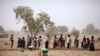 Des gens travaillent le 21 mars 2012 dans un champ dans le cadre d'un programme de travail contre rémunération géré par une ONGpour construire des digues pour retenir l'eau près de Diapaga au nord-est de Ouagadougou. (Photo de RAPHAEL DE BENGY / AFP)