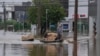 Voluntarios transportan suministros donados valiéndose de un bote a través de una calle inundada después de fuertes lluvias en Porto Alegre, estado de Rio Grande do Sul, Brasil, el domingo 12 de mayo de 2024.