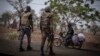 (FILE) A police officer and a soldier from Benin stop a motorcyclist at a checkpoint outside Porga, Benin, March 26, 2022.