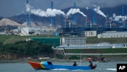 A boat cruises past the Indonesia Weda Bay Industrial Park in Central Halmahera, North Maluku province, Indonesia, Saturday, June 8, 2024. Indonesia has been building out a vast industry for nickel. (AP Photo/Achmad Ibrahim)