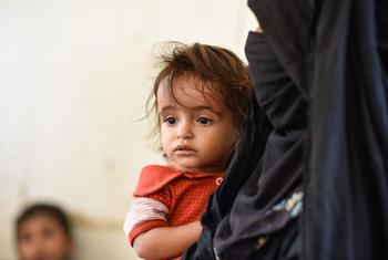 A mother brings her child to a mobile health clinic in Hajjah, Yemen.