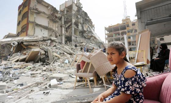 A girl sits among the rubble of destroyed buildings in Gaza.