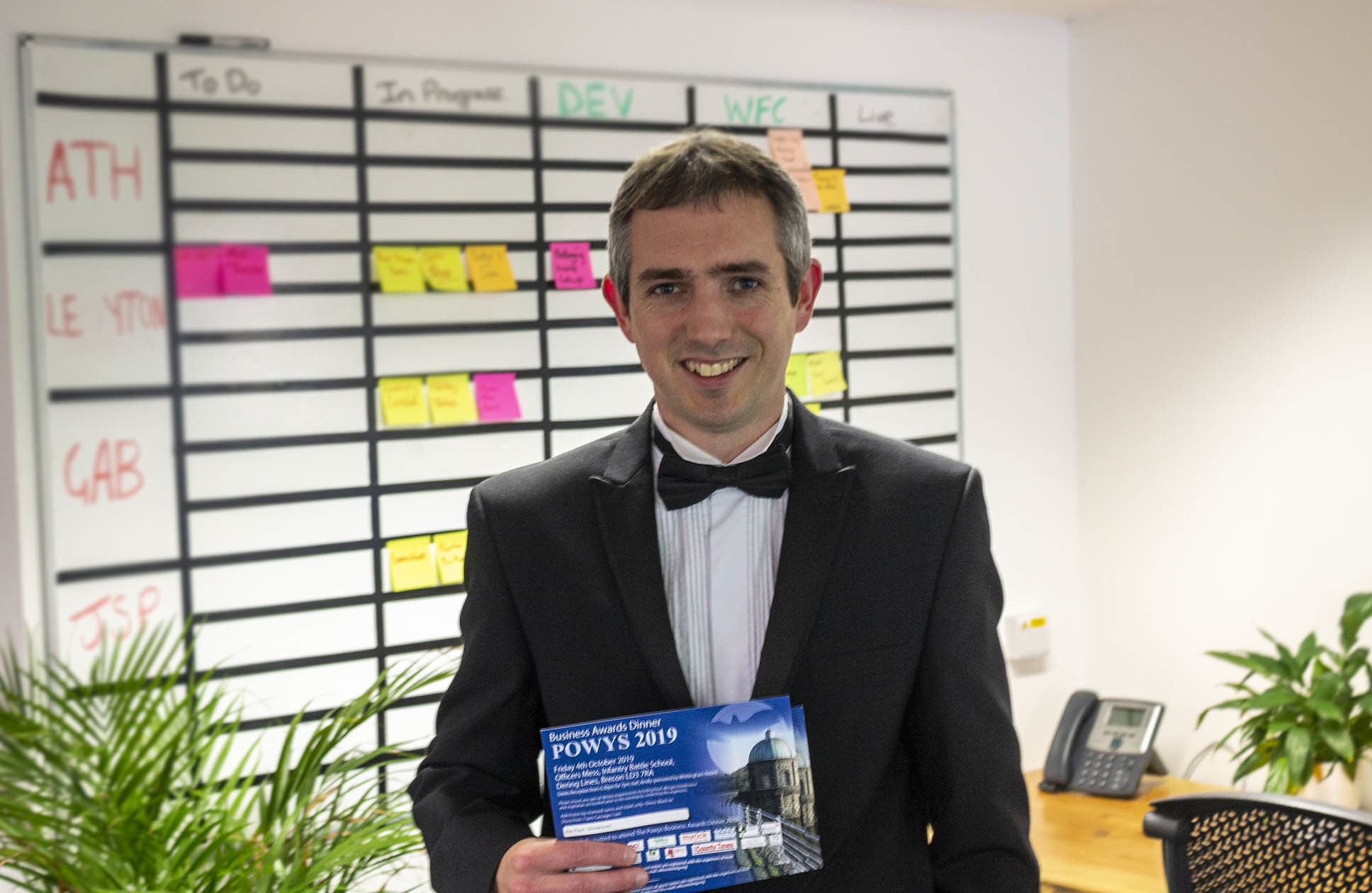 gloversure managing director holding powys small business awards in an office