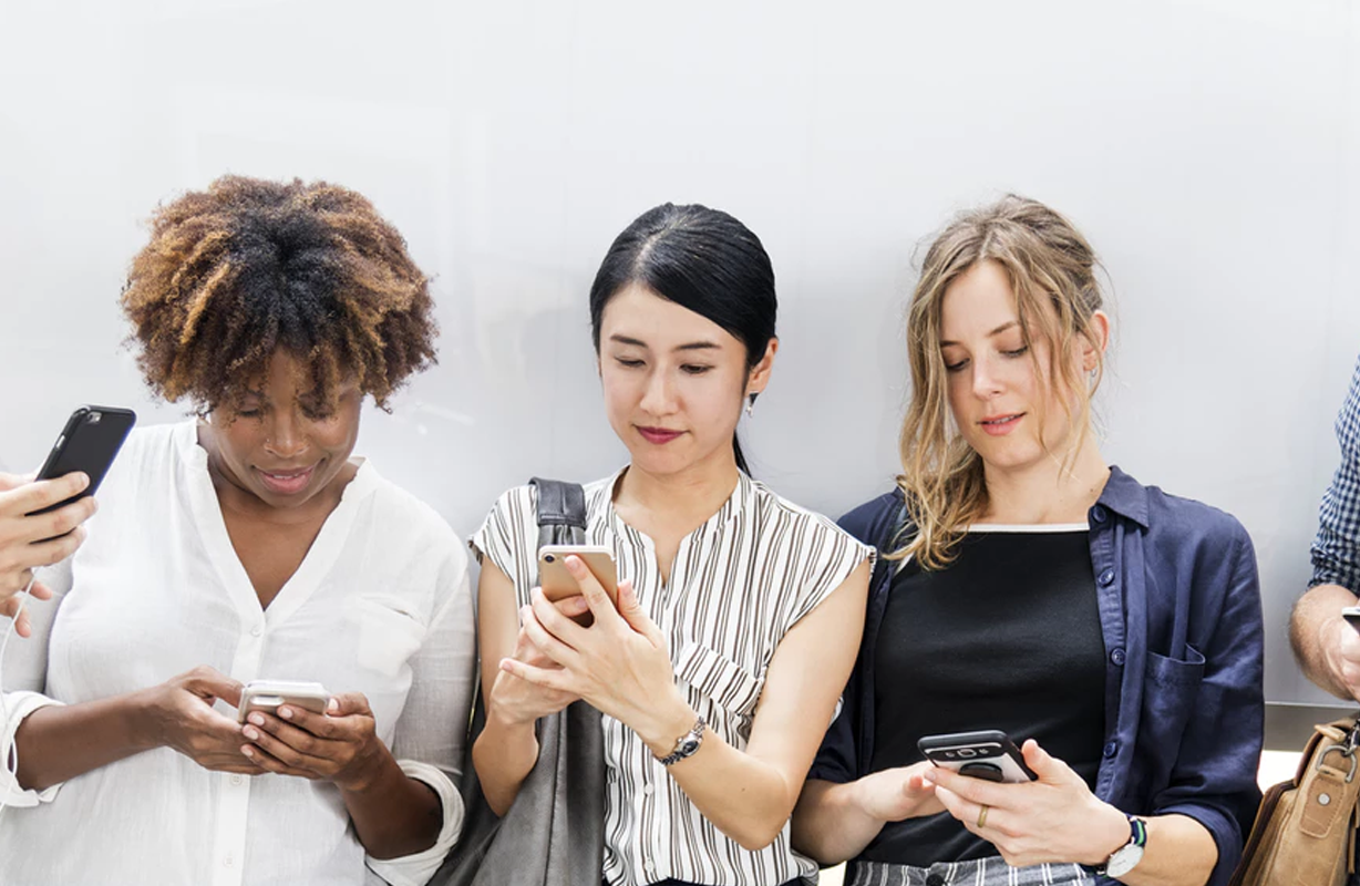 Five people lined up all looking at social media content on their phone