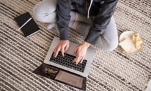 woman sitting on ground working on macbook air