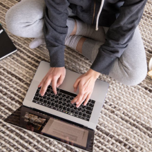 woman sitting on ground working on macbook air