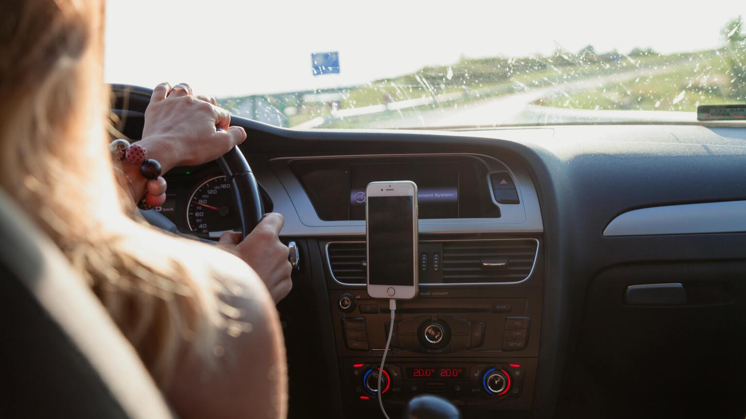 woman driving car with phone in hands-free position