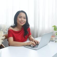 Woman in red dress working in an office.