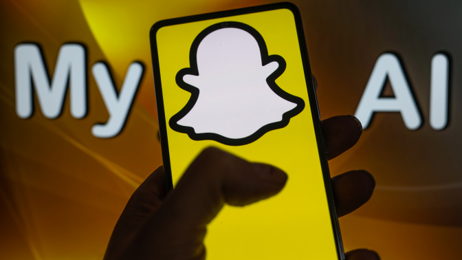 A phone displays the Snapchat logo in front of a screen that reads "My AI". 