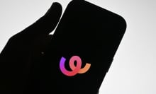 The silhouette of a hand holding a phone that displays the Whee logo. 
