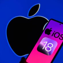 The Apple iOS 18 logo is being displayed on a smartphone with the Apple logo in the background