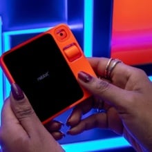 woman's hands holding up the Rabbit R1 gadget