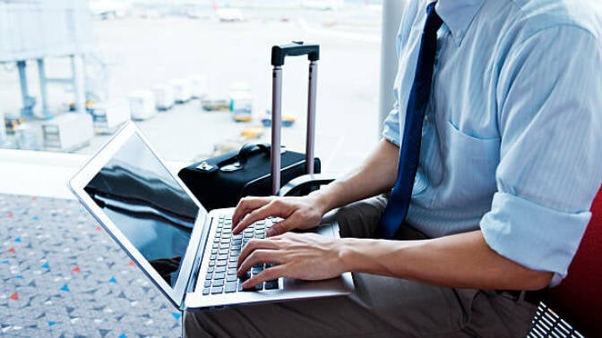 Man looking for travel deals at airport.