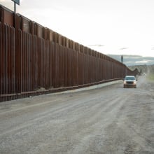 Evening Shot of Border Wall Between El Paso Texas USA and Juárez Chihuahua Texas at Puerto Anapra with US Border Patrol Vehicle in the Distance