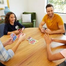 A family plays UNO around a table