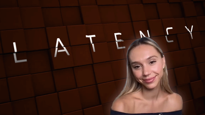 Alexis Ren smiling in front of the film's poster art