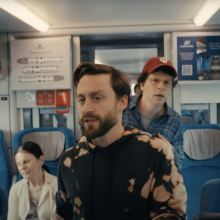 Kieran Culkin and Jesse Eisenberg walk through a train in Poland in the film "A Real Pain."