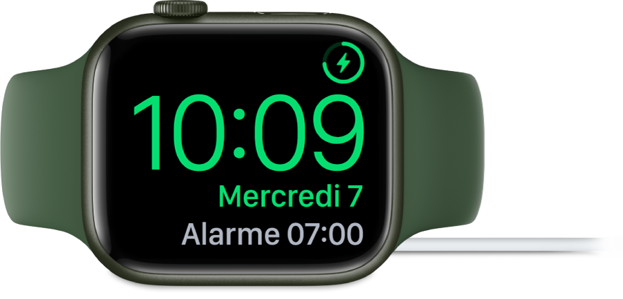 Apple Watch placée sur sa tranche et connectée au chargeur. L’écran montre le symbole de recharge dans le coin supérieur droit, l’heure actuelle en dessous et l’heure du prochain réveil.