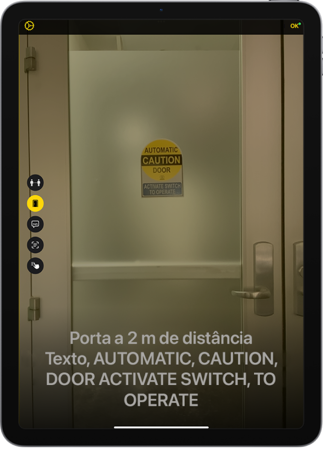 Tela da Lupa no Modo de Detecção mostrando uma porta. Na parte inferior encontra-se uma descrição da distância até a porta e o texto que se encontra nela.