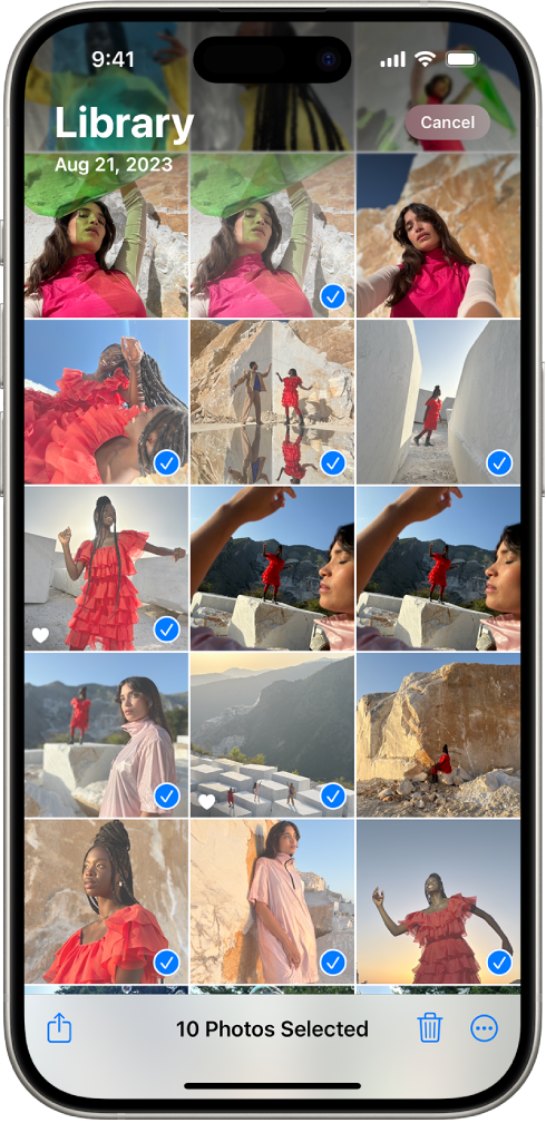 El iPhone muestra una cuadrícula de fotos que ocupa toda la pantalla, y algunas de las fotos están seleccionadas. En la parte inferior de la pantalla se encuentran los botones Compartir, Eliminar y Más.